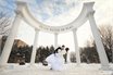 жених и невеста целуются под аркой зимой