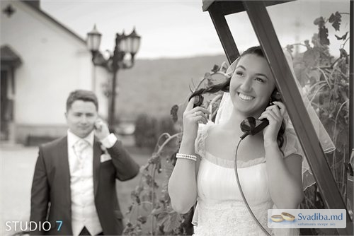 Улыбающаяся невеста говорит из телефонной будки с 