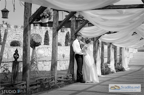 Жених целует невесту под шатром
