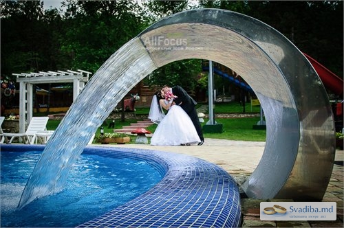 Tineri casatoriti se sarut la piscina cu cascada.